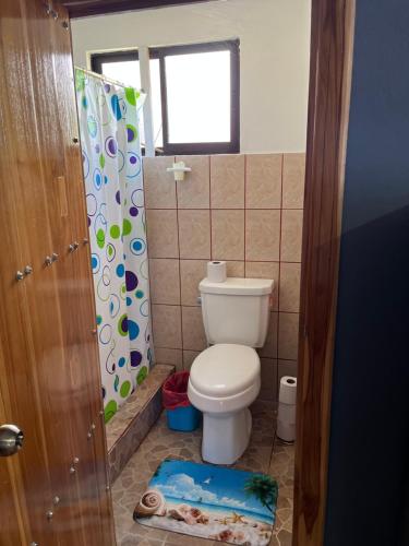 a bathroom with a toilet and a shower curtain at Estudio Mar Azul in Puntarenas