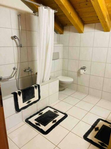 a white bathroom with a shower and a toilet at Sternen B&B & Italienisches Restaurant in Elm