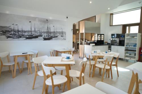 a restaurant with tables and chairs and a kitchen at Horta Bay in Horta