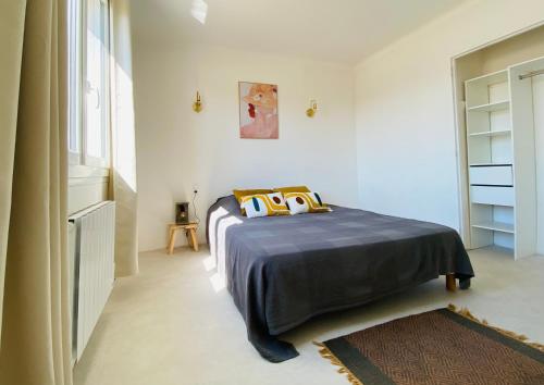 1 dormitorio con 1 cama en una habitación blanca en Appartements Cabiscol en Beaucaire