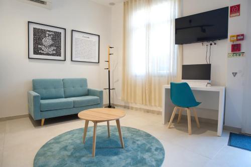 a living room with a blue couch and a table at Horta Bay in Horta