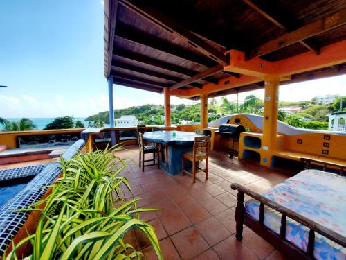 a patio with tables and chairs and a view of the ocean at Reef View Pavilions - Villas & Condos in Lance aux Épines