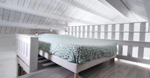 ein Schlafzimmer mit einem Bett in einem weißen Zimmer in der Unterkunft Chalet cosy, plages à pieds. Morbihan. in Plouhinec
