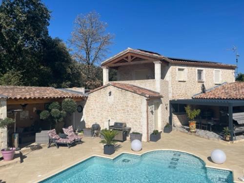 une maison avec une piscine dans une cour dans l'établissement appartement avec piscine, à Arpaillargues-et-Aureillac