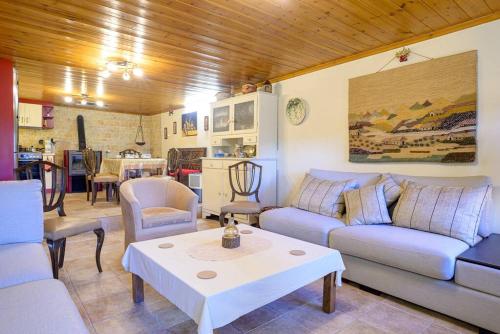 a living room with couches and a table and a kitchen at Clio's Stone House in Kipoi