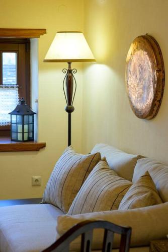 a lamp sitting next to a couch in a living room at Clio's Stone House in Kipoi