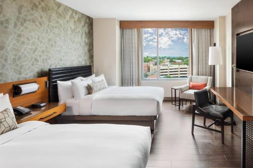 a hotel room with two beds and a desk at Lancaster Marriott at Penn Square in Lancaster