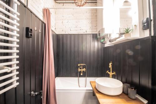 een badkamer met een wastafel en een ligbad bij Corvin Loft in Boedapest