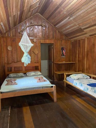 Duas camas num quarto com paredes de madeira em Amazônia Exxperience em Manaus