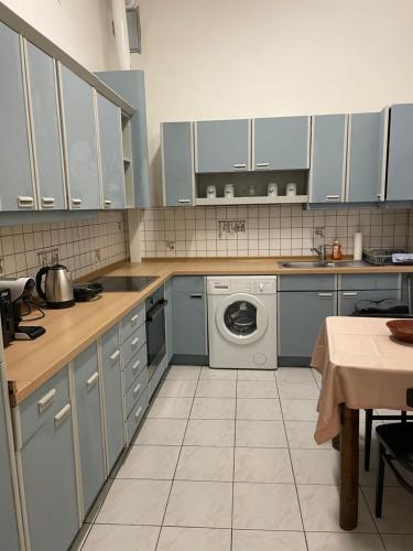 une cuisine avec des armoires bleues et un lave-linge dans l'établissement Apartment 1080, à Vienne