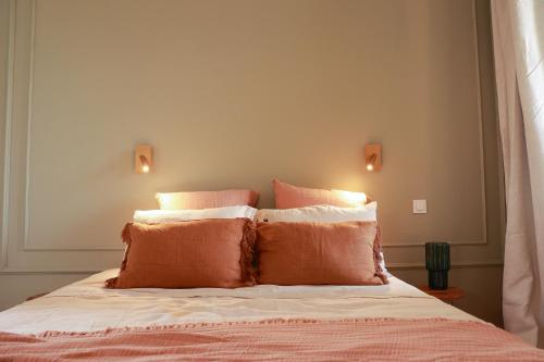 une chambre avec un lit avec des oreillers orange et blancs dans l'établissement Maison Arcades chambre 3, à Verdun-sur-Garonne