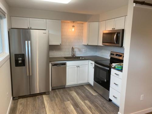 a kitchen with white cabinets and a stainless steel refrigerator at Valley Escape in Quiet Area Neighborhood in Spokane Valley