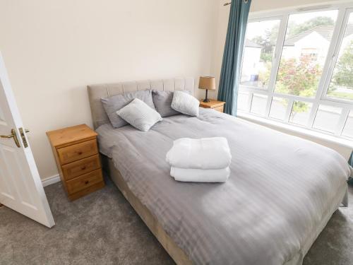 a bedroom with a large bed with a white chair on it at 39 Quignalecka in Ballina