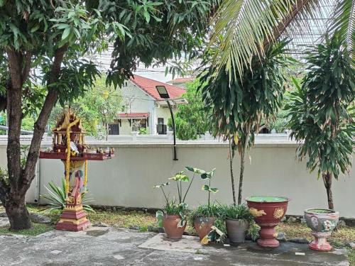 a garden with plants and a bird house and trees at ksana guesthouse in Luang Prabang
