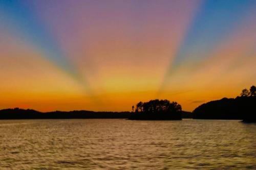 a rainbow in the sky over a body of water at Cozy 4br Lake Lanier GA Waterfront- Great Location in Gainesville