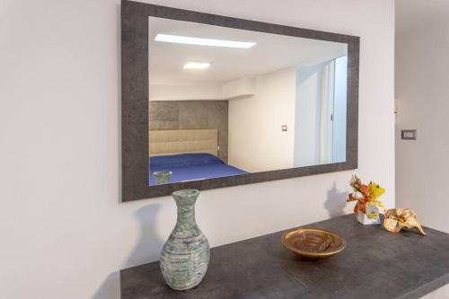 a mirror on a wall above a table with a vase at Residenza Botticelli in Lecce