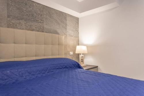 a bedroom with a blue bed and a lamp at Residenza Botticelli in Lecce