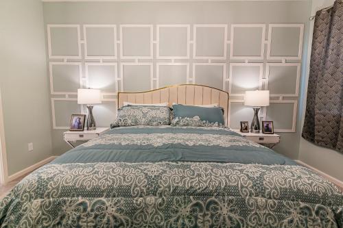 1 dormitorio con 1 cama grande y 2 lámparas en Luxury 12 bedrooms pool house 10 Min to Disney, en Kissimmee