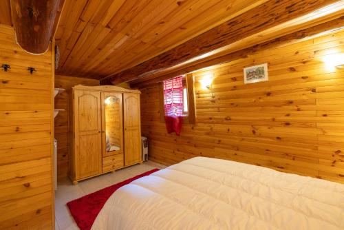 1 dormitorio con 1 cama en una cabaña de madera en Chalet D'alpage Authentique, en Queige