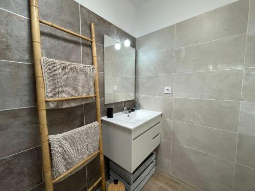 La salle de bains est pourvue d'un lavabo et d'un sèche-serviettes. dans l'établissement Tierra Del Viento - Villa Proche de la Mer, à Peyriac-de-Mer
