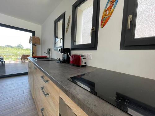 - une cuisine avec un comptoir et une télévision dans l'établissement Tierra Del Viento - Villa Proche de la Mer, à Peyriac-de-Mer