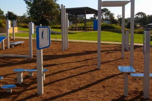 a playground with blue and white equipment in a park at A Reef Intermission - A coast break at Mollymook in Mollymook