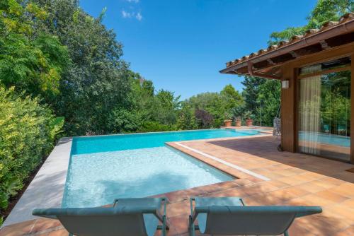 a swimming pool with chairs next to a house at Villa Casa Del Talaiot Sencelles in Sencelles
