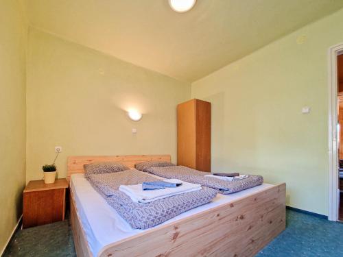 a bedroom with a bed with two towels on it at Lepke Apartman in Harkány