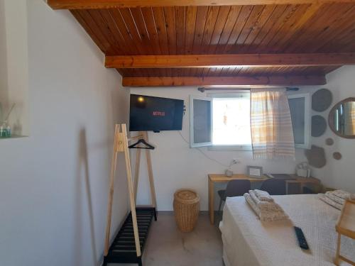 um quarto com uma cama, uma secretária e uma janela em Alfa Loft (by Lemon Tree Houses) em Vrachati