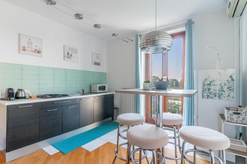 a kitchen with a counter and stools in it at CasaTella - Monolocale - letto matrimoniale - angolo cottura - bagno e balcone in Vidigulfo