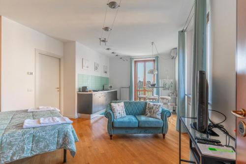 a bedroom with a bed and a couch and a tv at CasaTella - Monolocale - letto matrimoniale - angolo cottura - bagno e balcone in Vidigulfo