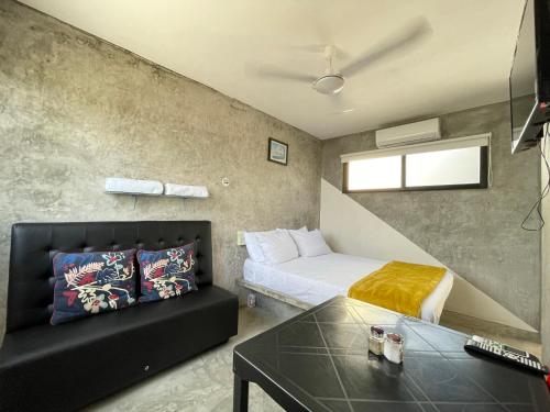 a small room with a bed and a couch at Casa y departamentos lavanda in Mérida
