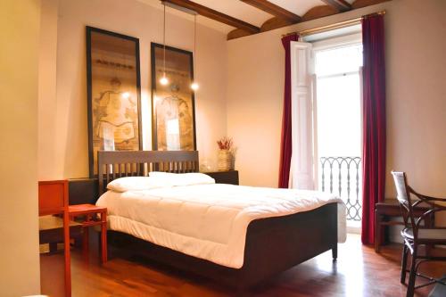 um quarto com uma cama grande e uma janela em Estudio Ciutat Vella al lado de Jardines del Turia em Valência