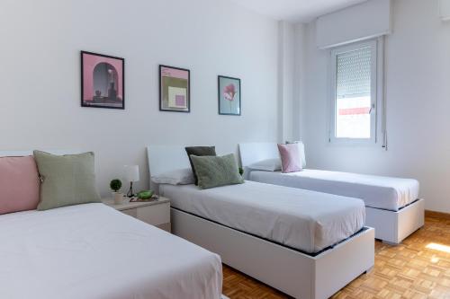 a white room with two beds and a couch at Darsena Luminous & Cozy Apartment in Ferrara