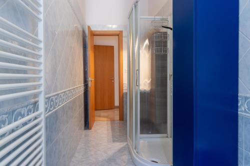 a bathroom with a walk in shower and a glass door at Darsena Luminous & Cozy Apartment in Ferrara