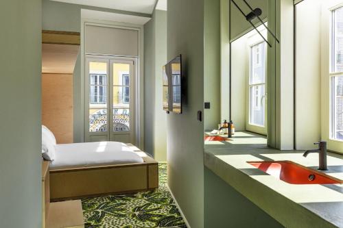 - une chambre avec un lit et une salle de bains pourvue d'un lavabo dans l'établissement Independente Bica, à Lisbonne