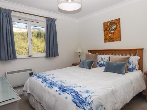 a bedroom with a large bed with blue and white sheets at 14 Burgh Island Causeway in Kingsbridge