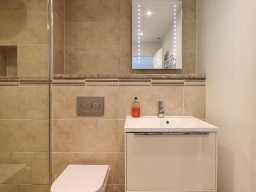 W łazience znajduje się toaleta, umywalka i lustro. w obiekcie 14 Burgh Island Causeway w mieście Kingsbridge