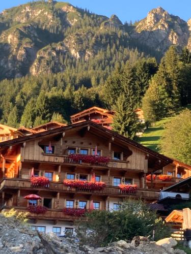 a hotel in the mountains with mountains in the background at Aparthaus Sonnenhof in Alpbach