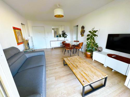 a living room with a couch and a table at Charme et Douceur By UTA HOUSE in Saint-Denis