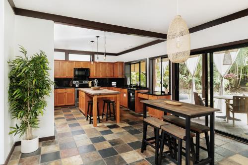 a kitchen with wooden cabinets and a table and chairs at The Bamboo House in Kailua-Kona