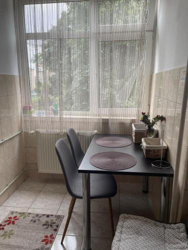 a table and chairs in a room with a window at Ultracentral Studio in Craiova