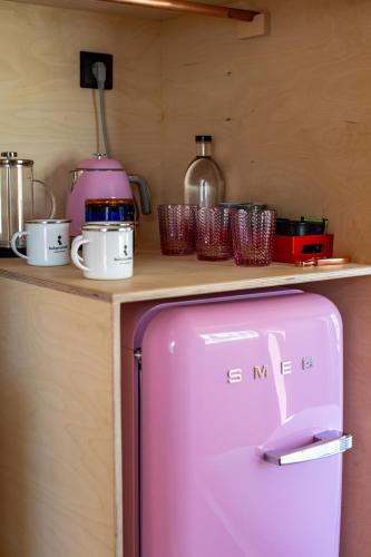 a pink refrigerator sitting on top of a counter at Independente Bica in Lisbon