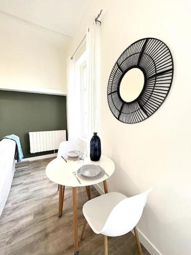 Cette chambre comprend une table, deux chaises et un miroir. dans l'établissement L'Agate bleue - Bourg-de-Péage, à Bourg-de-Péage