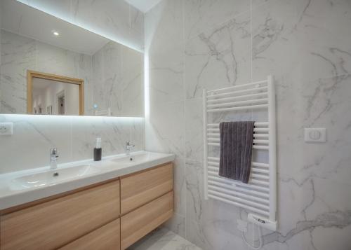 une salle de bain blanche avec un lavabo et un miroir dans l'établissement SUPERB FLAT WITH 2 BEDROOMS NEAR PALAIS CROISETTE 3P2, à Cannes