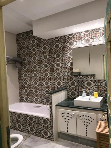 een badkamer met een bad, een wastafel en een toilet bij Dar Aron Tozeur in Tozeur
