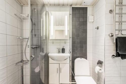 a white bathroom with a sink and a shower at Upea 2 makuuhuoneen huoneisto lähellä lentokenttää! in Vantaa
