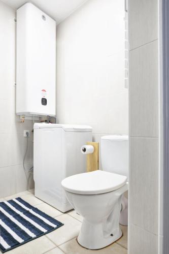 La salle de bains est pourvue de toilettes blanches et d'un tapis bleu. dans l'établissement La Saline - Second Souffle - Cherbourg, à Cherbourg en Cotentin