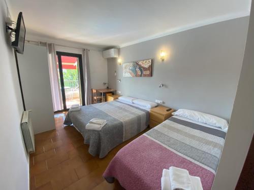 a hotel room with two beds and a window at Hotel Les Roques in Báscara