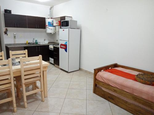 モロンにあるDepartamento en Morónのキッチン(白い冷蔵庫、テーブル、椅子付)